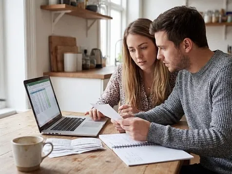 A couple reviewing paperwork and bills together at their kitchen table